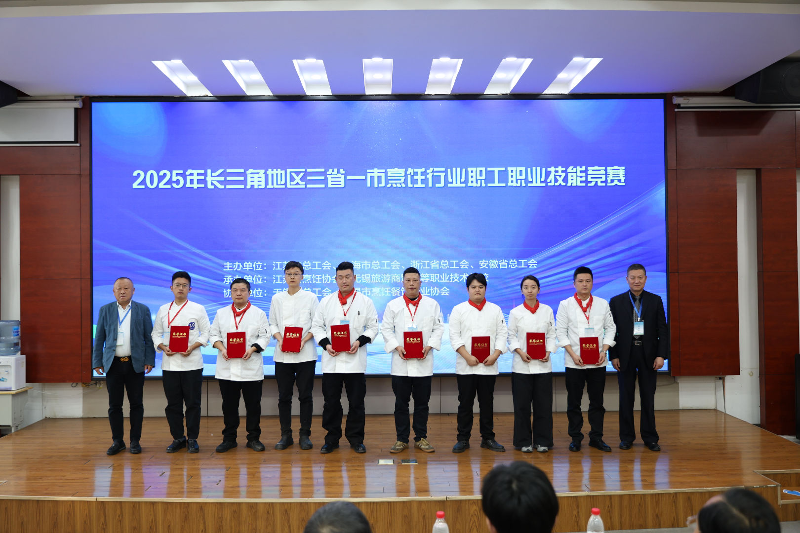 江苏省烹饪协会会长牛坤(左1)、无锡协会会长陈为民(右1)为屠明亮(左2)邵俊锋(左4)老师颁发二等奖证书